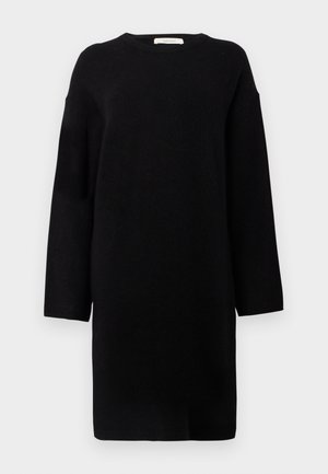 Zwarte gebreide jurk met lange mouwen, ronde hals en een relaxte pasvorm. Zachte textuur en design tot op de knie. Geen patronen of accenten zichtbaar.