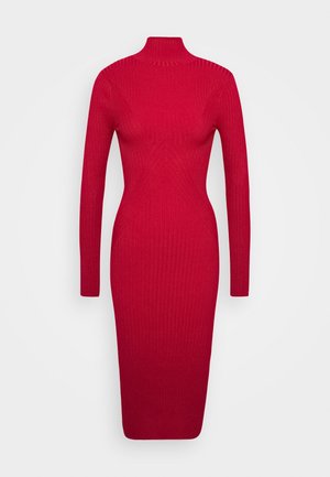 Robe rouge en tricot côtelé à manches longues, longueur aux genoux, avec un col montant et une silhouette ajustée sur fond blanc.