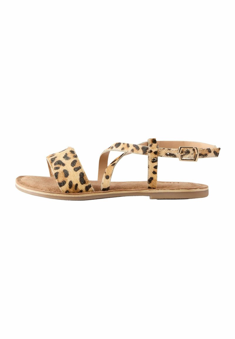 Leopardenmuster Flachsandalen mit zwei Kreuzriemen und einer verstellbaren Schnalle, ausgestattet mit einer weichen beigefarbenen Fußbett und einer glatten tanfarbenen Sohle.