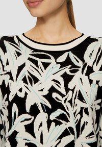 Maglione nero con motivi floreali bianchi e azzurri, con scollatura rotonda e bordo a coste a contrasto. Tessuto morbido.