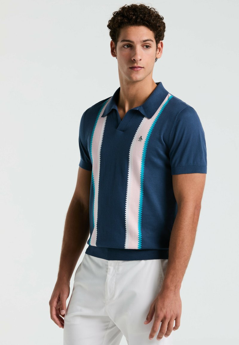 Marineblauwe polo met korte mouwen en verticale strepen in pink en turquoise, met een kraag en een logo op de linkerborst. Gemaakt van een katoenmix.