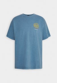 Blå bomull T-shirt med rund hals, kortärmar och ett cirkulärt gult grafiskt tryck på vänster bröst. Klassisk passform med mjuk textur.