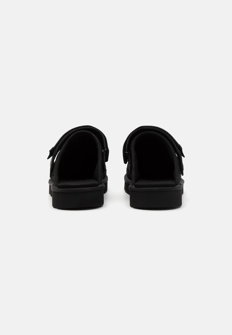 Sandali neri con un design minimalista, dotati di cinturini regolabili, una texture liscia e una suola imbottita per il confort.