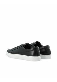 Sneaker nere in pelle con finitura liscia, suola in gomma bianca, punta rotonda e sistema di allacciatura frontale. Dettaglio del marchio sul tallone.
