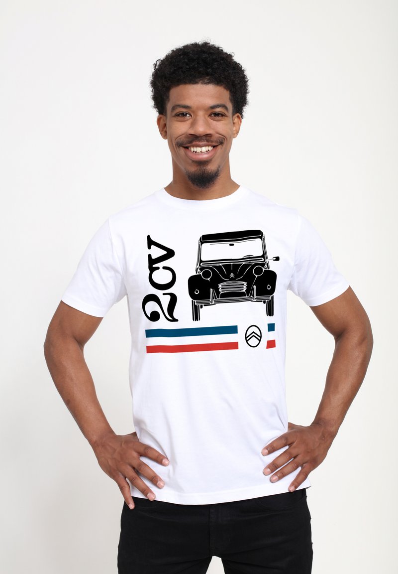 Bílé tričko s krátkým rukávem, na kterém je černá grafika auta, text "2CV" a vodorovné modré a červené pruhy na spodní části. Jednoduchý design.