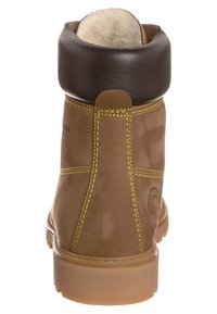 Bota de cuero marrón con puntera redonda, un cuello acolchado marrón, costuras amarillas y una suela texturizada color beige. Presenta un logo en el costado.