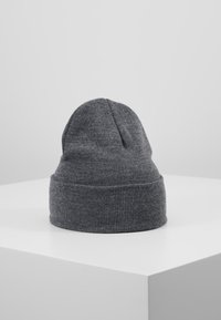 Grå strikket hue med en ophøjet kant. Blød tekstur og en let slasket design, med en sømløs top og uden synlige logoer eller mønstre.