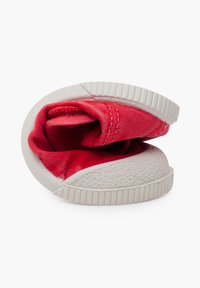 Sneaker in tessuto rosso con suola in gomma bianca testurizzata, caratterizzato da una forma arrotondata e un rivestimento interno morbido, progettato per comfort e flessibilità.