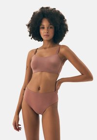 Bikini set in muted pink; features a padded, smooth bralette and ribbed high-waisted bottoms, both with adjustable straps.