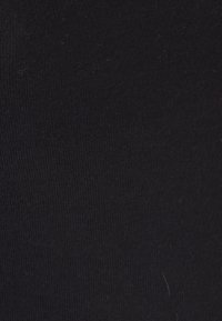 Tejido de algodón negro con una textura suave, que presenta un patrón de punto liso y uniforme, sin costuras ni adornos visibles.