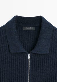 Maglione in maglia costina blu navy scuro con cerniera frontale argento e ampio collo a risvolto, con etichetta Massimo Dutti all'interno del collo.