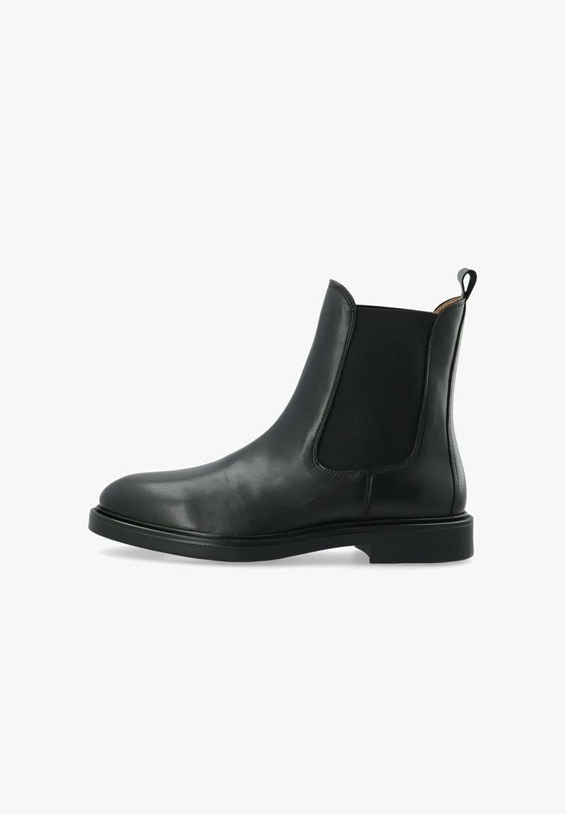 Stivale Chelsea in pelle nera con pannelli elastici ai lati, una linguetta per facilitare la calzata e una suola in gomma piatta. Texture liscia con punta rotonda.