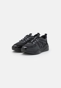 Sneaker neri con un mesh testurizzato e materiale liscio, punta arrotondata e suola prominente con una piattaforma rialzata. Inclusi lacci regolabili.