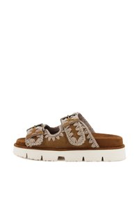 Bruna mockaskinnsandaler med vit plattformssula, med dekorativ brodyr på remmarna och justerbara spännen. Texturerad yta.