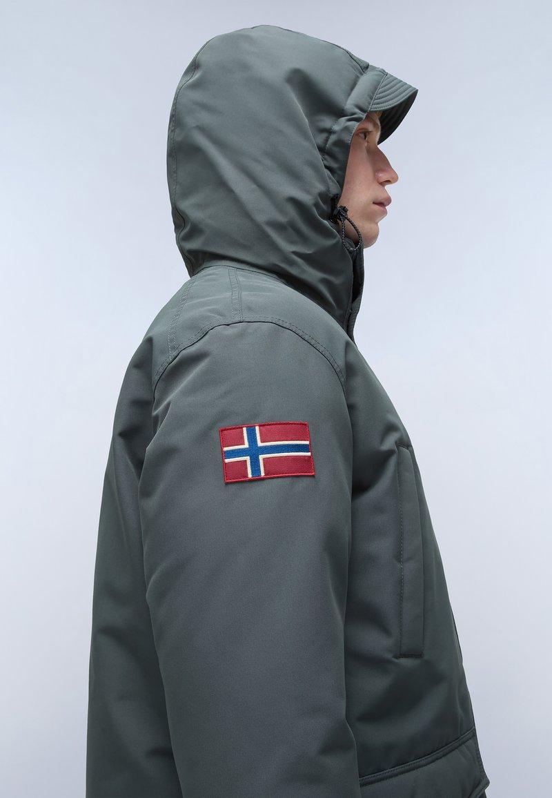 Veste à capuche gris foncé avec un patch de drapeau norvégien sur le haut du bras. Doublée d'une texture lisse et d'un tissu durable.