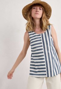 Bez rękawów, w paski w kolorze granatowym i białym, z unikalnym wzorem na przemian szerokich i wąskich pasków. Materiał bawełniany, luźny krój.