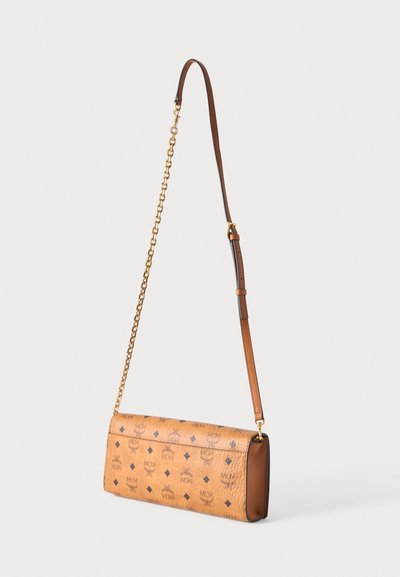 Sac bandoulière MCM en cuir fauve avec bandoulière chaîne dorée et section en cuir ajustable, avec impression du logo et motifs diamant.