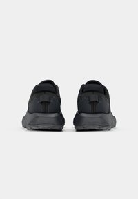 Schwarze Sportschuhe mit einem strukturierten Mesh-Obermaterial, verstärktem Fersenbereich und Gummisohle mit einem robusten Profil für besseren Halt.