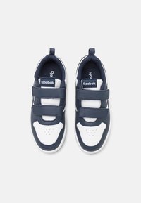 Mornarske i bijele tenisice od glatkog sintetičkog materijala, s trakama na čičak, perforiranim vrhom i Reebok oznakom.