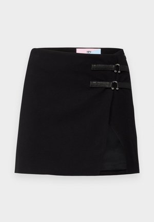 Czarna mini spódnica z krojem na zakładkę, z dwoma dekoracyjnymi czarnymi paskami z metalowymi akcentami z przodu. Gładka tekstura materiału.