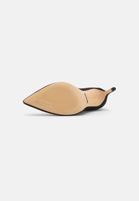 Décolleté neri con punta affusolata, superiore in morbido camoscio, tacco affusolato e suola in gomma beige con linee di grip testurizzate e marchio.