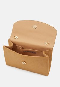 Pochette en daim beige avec rabat arrondi, fermeture éclair dorée et compartiments intérieurs. Comprend une étiquette intérieure portant la mention "ANNA FIELD."