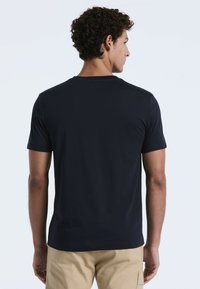 Marineblauwe T-shirt met korte mouwen van gladde stof met een ronde hals. Heeft een eenvoudig, onopgesmukt ontwerp en een standaard pasvorm.