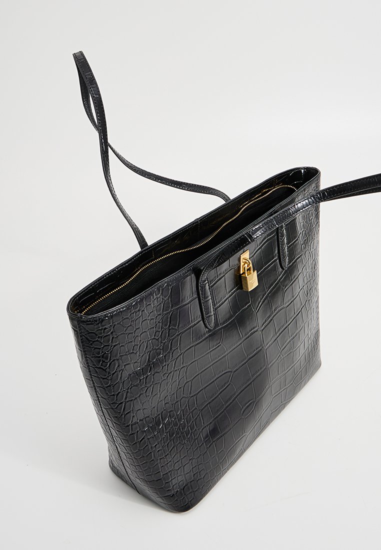 Black crocodile-patterned tote bag with dual handles and a central gold lock. Features a zip closure and spacious interior.