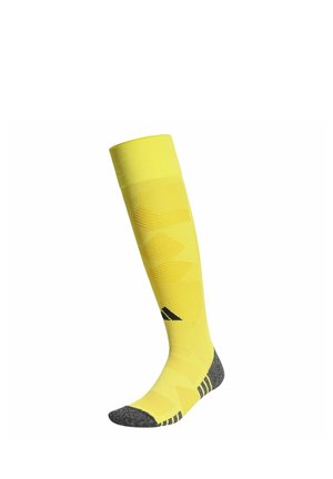 Chaussette de sport haute jaune avec talon, pointe et accents rayés noirs, avec un logo noir sur la zone du tibia.