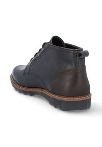 Botín de cuero negro con acentos marrones, suela de goma robusta, puntera redonda y diseño con cordones. Presenta un ribete cosido y una lengüeta para ayudar a calzarlo.