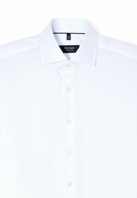Witte button-up shirt gemaakt van gestructureerd katoen, met een klassieke kraag, zes knopen en een label met "OLYMP SIGNATURE."