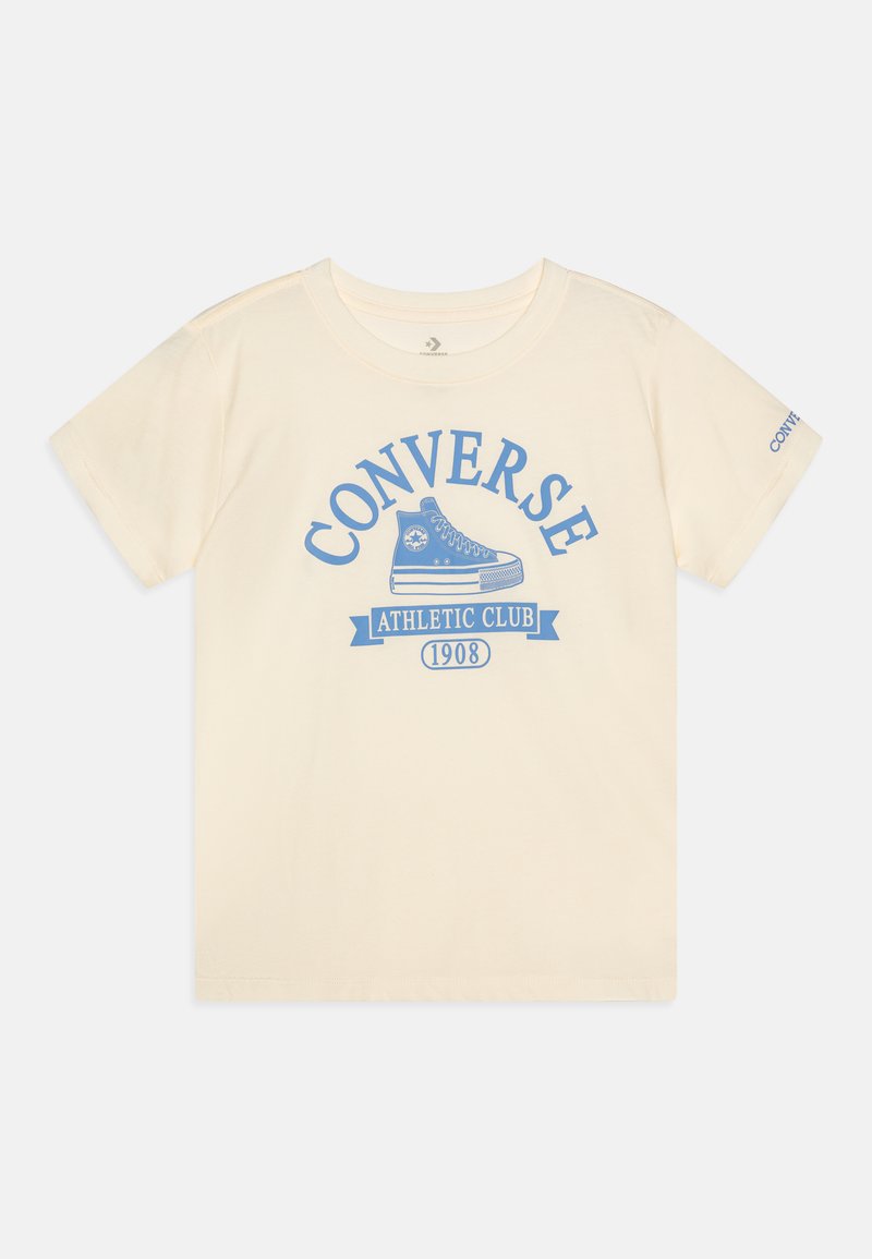 T-shirt crème en coton à manches courtes. Présente un texte et un logo graphique bleu "CONVERSE ATHLETIC CLUB 1908" sur le devant.
