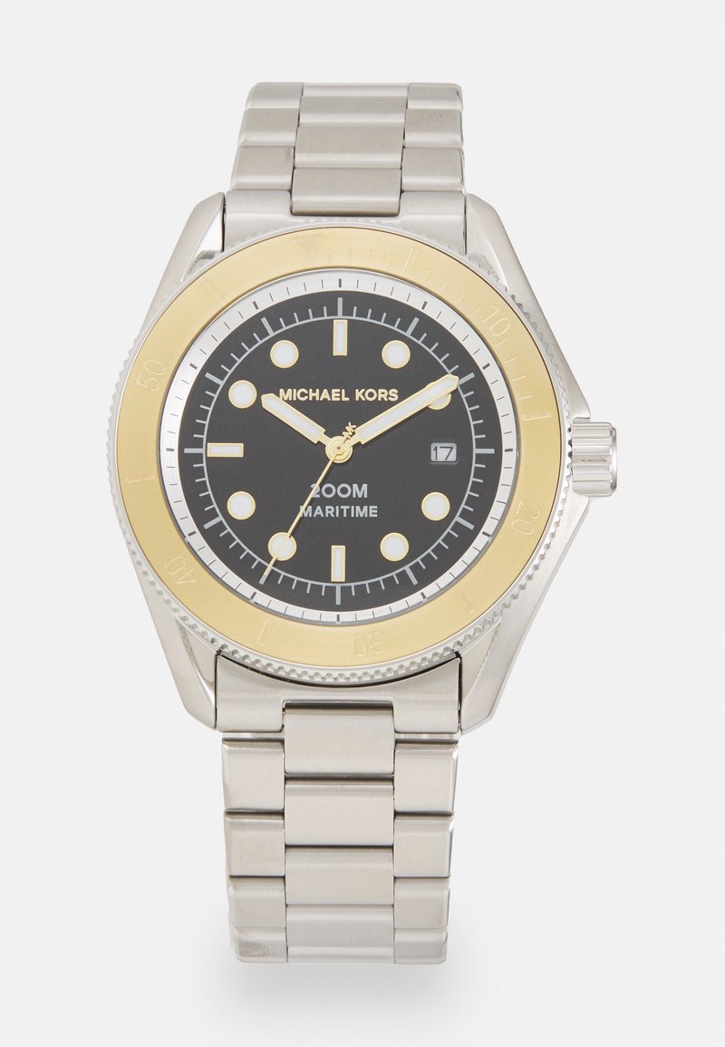 Sidabrinis nerūdijančio plieno laikrodis su juodu ciferblatu, auksine rėmeliu ir apvaliu veideliu. Yra valandų žymenys, datos langelis ir metalinė grandinėlė.