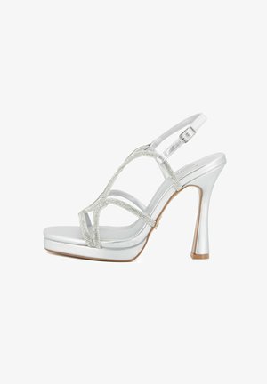 Sandalo argento con tacco alto e suola platform, cinturini decorati con strass e fibbia regolabile alla caviglia, mostrato di profilo.