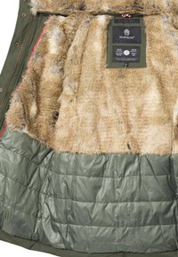 Grön parka med en mjuk brun fuskpälsfoder. Insidan har kviltade sektioner och en varumärkesetikett nära kragen. Ingen exteriör vy.