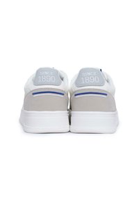 Sneakers bianchi con accenti in suede grigi, punta rotonda, suola piatta in gomma bianca e la scritta in rilievo "SINCE 1890" sul tallone. Design minimalista.