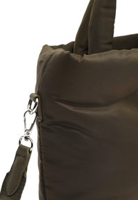 Brown quilted bag with smooth texture, featuring a detachable strap and metallic hardware. Rounded top edges and slightly puffy design.