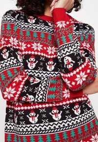 Maglione lavorato a maglia rosso e nero con motivi di pupazzi di neve e fiocchi di neve, alberi verdi e dettagli bianchi. Collo rotondo e polsini a costine.