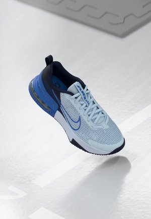 Hellblaue Sportschuh mit Mesh-Obermaterial, marineblauen Akzenten und sichtbarer Luftpolsterung in der Sohle. Verfügt über eine strukturierte Außensohle und Schnürsenkel.