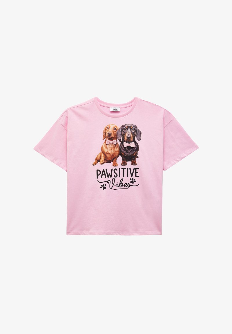 Camiseta de manga corta rosa con dos perros de dibujos animados que llevan pajaritas, con el texto "PAWSITIVE Vibes" en letras negras en negrita.