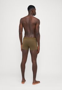 Brown men's boxer briefs, fitted design, smooth texture, elastic waistband, viewed from the back against a plain white background.