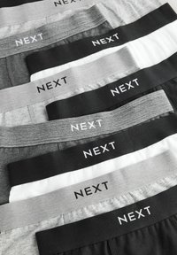 Blandet herreur med elastiske taljebånd i grå, sort og hvid, med "NEXT" logoet tydeligt vist på hvert bånd.