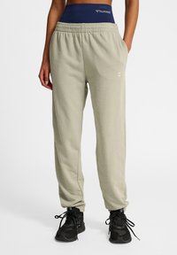 Ljusgrå sweatpants med elastisk midja, liten logodetalj och sidofickor. Mjuk bomullsblandning, tapered passform.