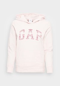 Sudadera con capucha de color rosa claro hecha de algodón con un bolsillo tipo canguro en la parte delantera. Presenta un logo "GAP" con patrón en rojo y blanco. Capucha con cordón ajustable.