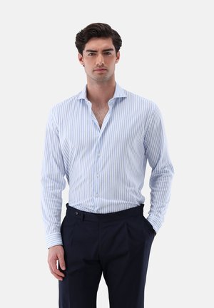 Camicia a righe in azzurro chiaro e bianco, con maniche lunghe e colletto a punta, abbinata a pantaloni blu navy. Presenta chiusure a bottone.