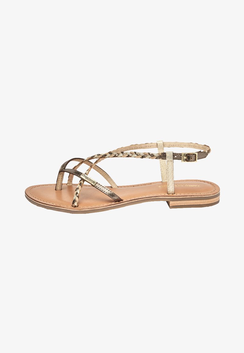Sandalo piatto con cinturini intrecciati metallici e neutri, dotato di una soletta color cappuccino e di un design minimalista con tacco basso.