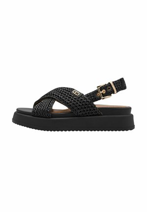 Sandalias negras tejidas con tiras cruzadas, cierre de hebilla y suela negra gruesa con agarre texturizado. Diseño ligero y transpirable.