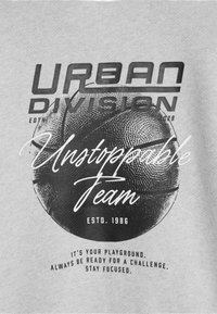 Szary sweatshirt z grafikami "Urban Division" i "Unstoppable Team", z teksturowaną ilustracją koszykówki oraz okrągłym wzorem tekstu.