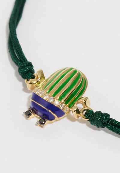 Prívesok v tvare chrobáka s zelenou a fialovou smaltovanou glazúrou, detailmi zo zlata, priezračnými kryštálikmi a čiernymi akcentmi na zelenom zapletenom šnúrke.