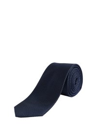 Mornarska kravata s teksturiranom tkaninom, s uzorkom malih plavih točkica, uredno smotana s oštrim krajem.
